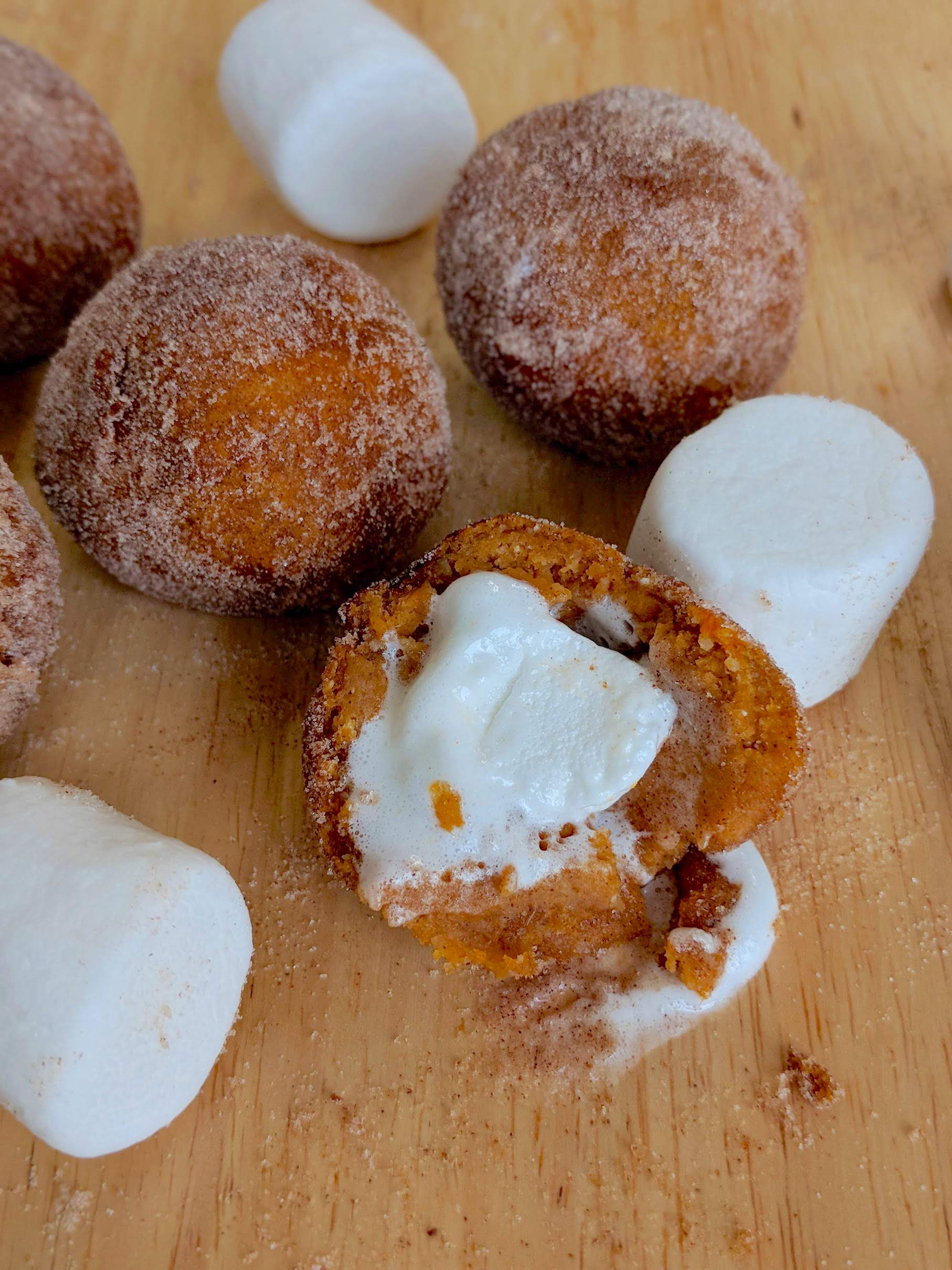a close up of a sweet potato donut hole stuffed with a marshmallow