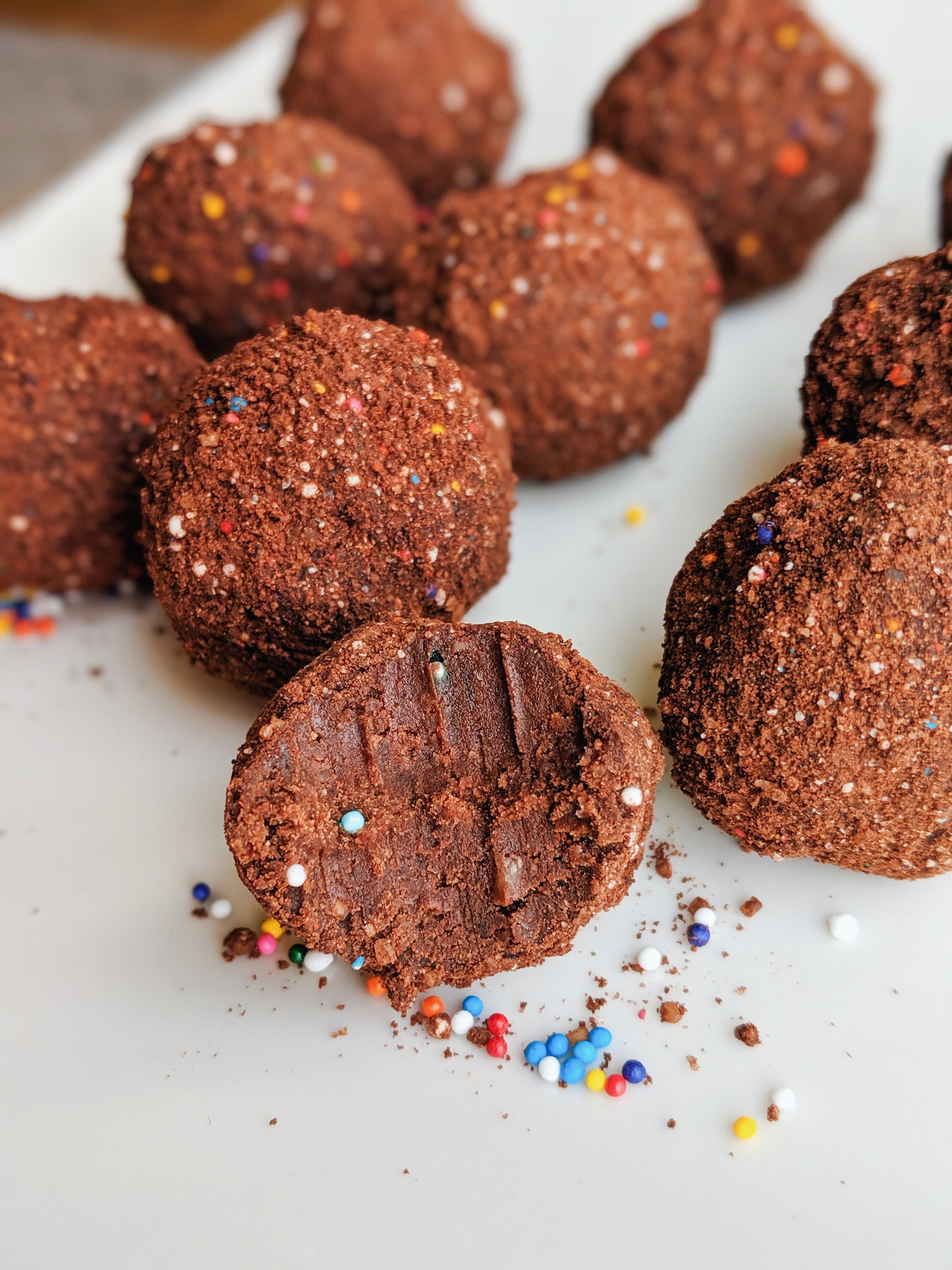 chocolate cake balls on a plate with sprinkles