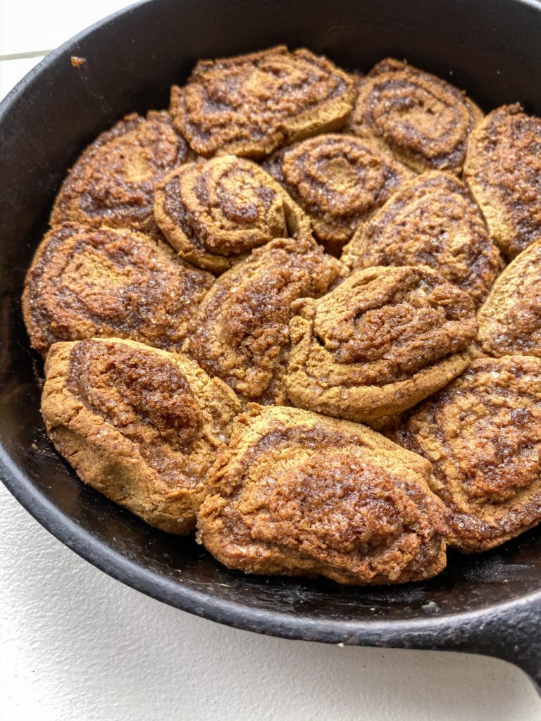 A skillet of sweet potato oat flour cinnamon rolls with cinnamon streusel