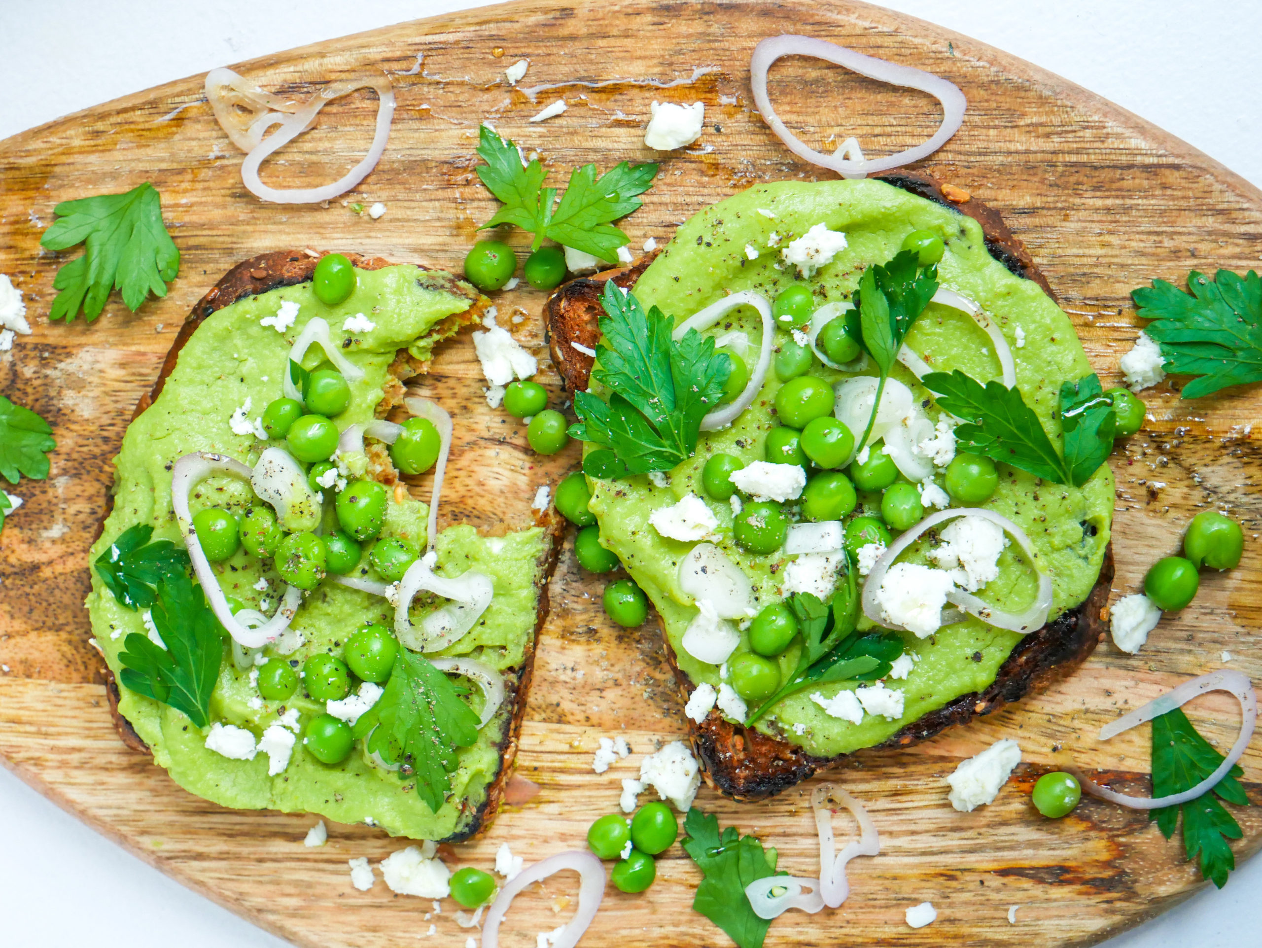smashed pea toast with shallots, feta, parsley and pepper