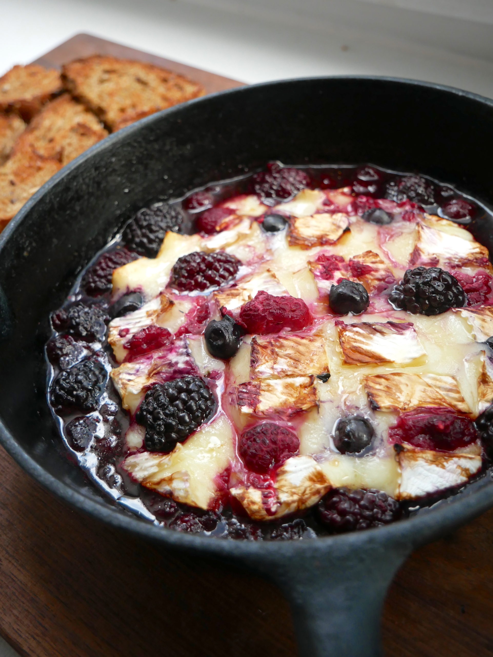 balsamic berry baked brie in a skillet with toast