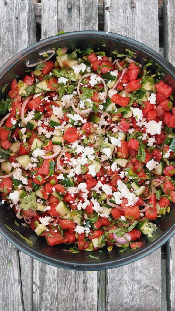 Refreshing watermelon salad with cucumber, lime, and Tajín chili lime seasoning, served as a healthy summer side dish with feta and fresh mint