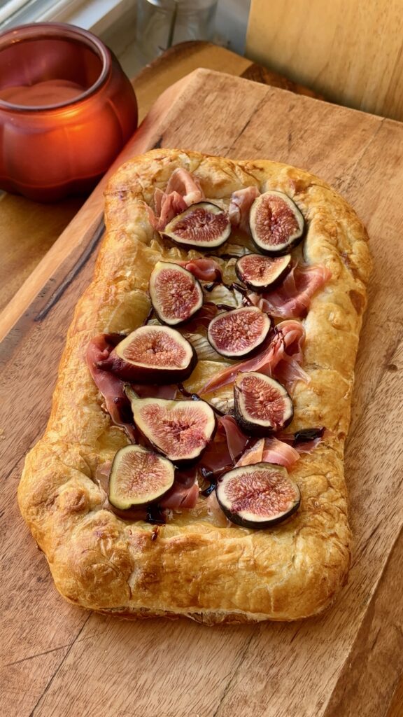 fig brie and prosciutto galette baked on a sheet pan with golden puff pastry