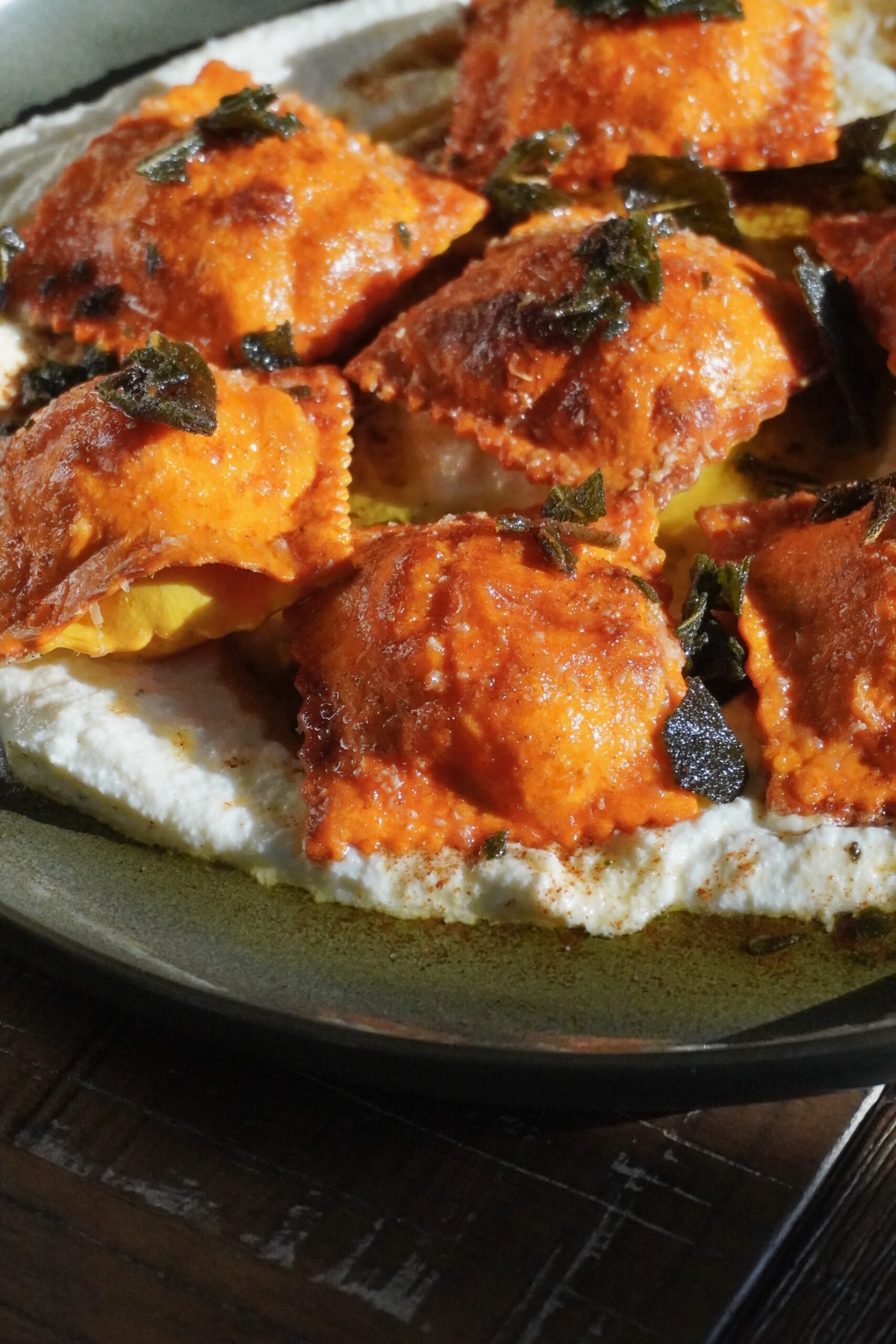 Close-up of golden pumpkin ravioli with crispy sage leaves