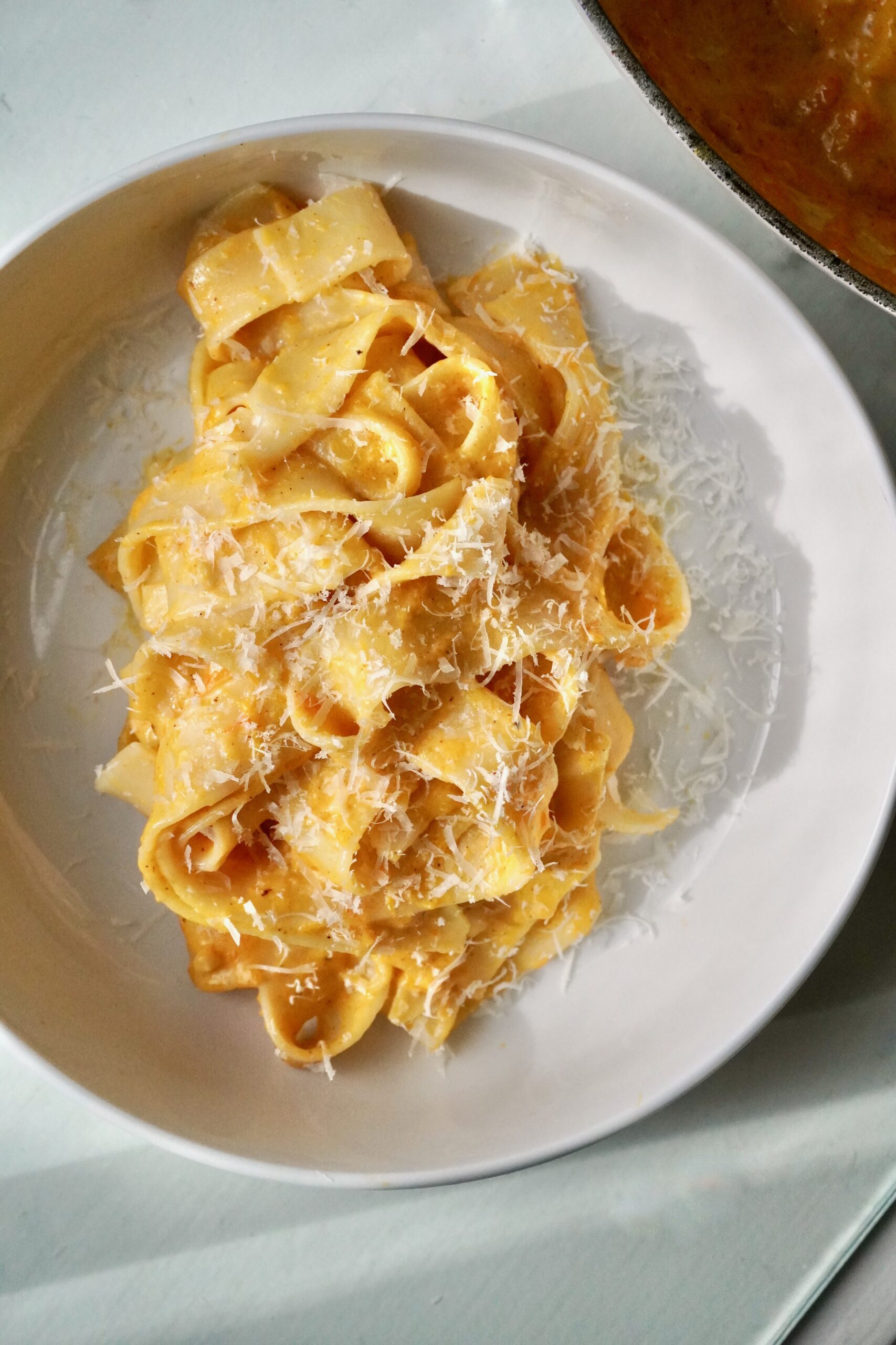 Elegant serving of brown butter honey nut squash Alfredo pasta on a neutral dinner plate.