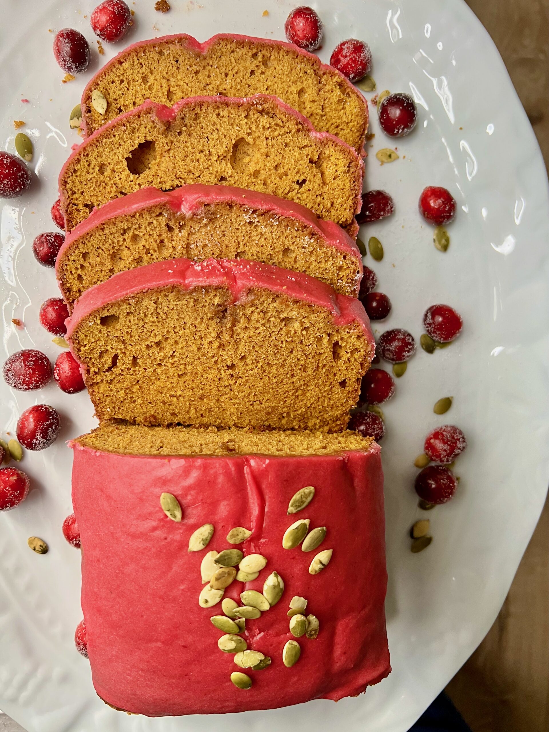 Overhead shot of pumpkin loaf with glossy pink-red glaze.