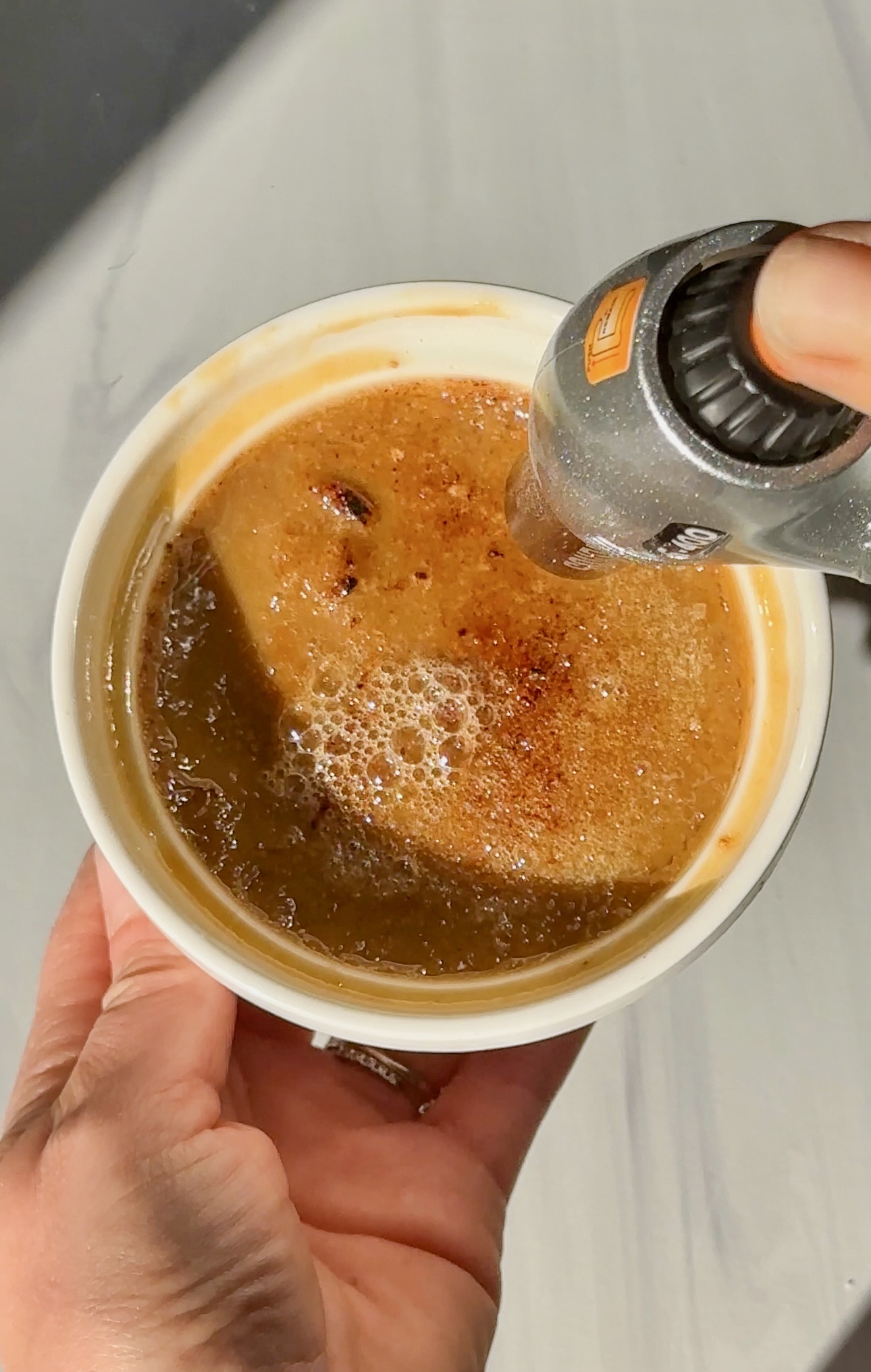 Chai crème brûlée with caramelized sugar crust and steam rising from the custard.