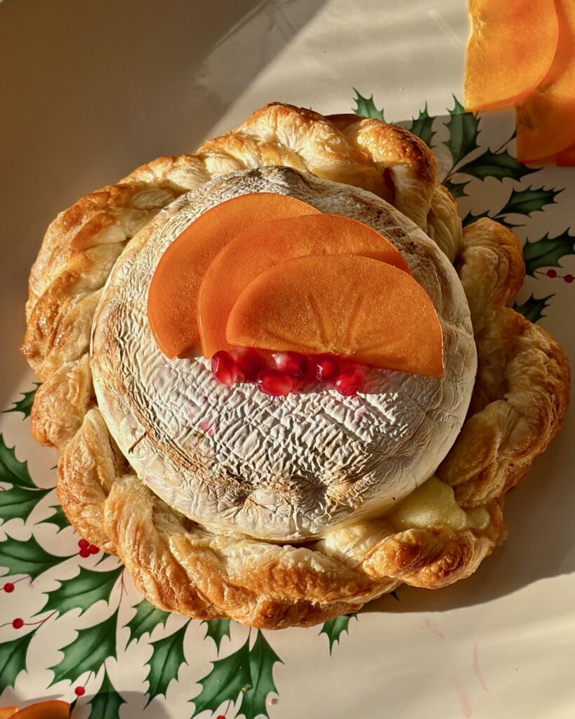 Festive persimmon and pomegranate baked brie centerpiece.