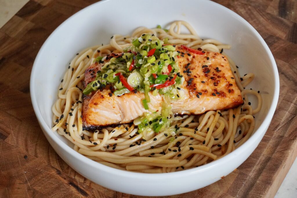 a bowl of salmon udon with lemongrass scallion oil