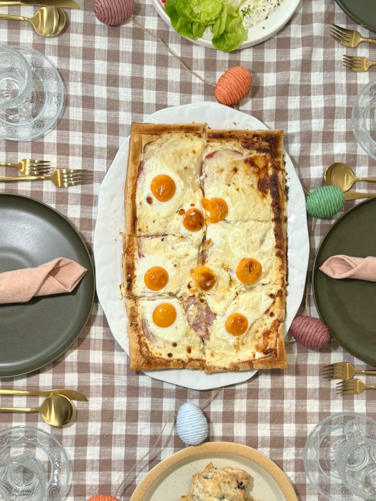 A brunch table setting featuring the Croque Madame tart alongside a fresh green salad