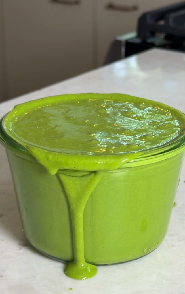 A glass jar filled with vibrant green Miso Green Goddess dressing