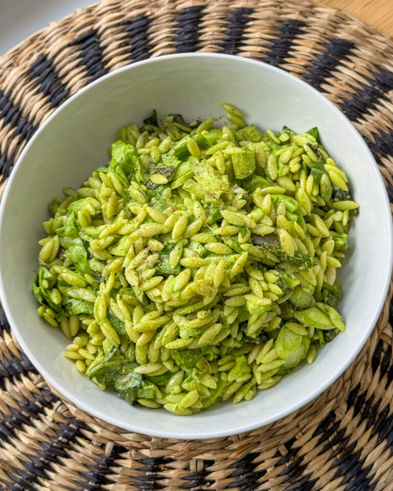 Bowl of green goddess orzo salad with asparagus and fresh herbs