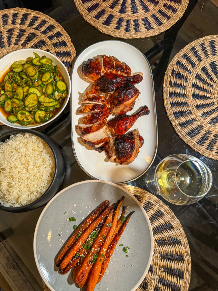 A carved Hoisin Spatchcock Chicken served alongside a fresh cucumber chili crunch salad