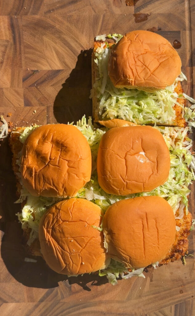 Party tray of chicken sliders with pickles and soft buns