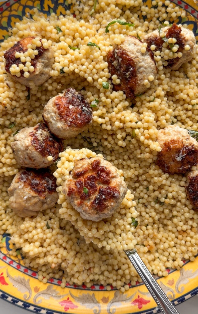 a big platter of balsamic turkey meatballs served over herby couscous with Parmesan and fresh basil