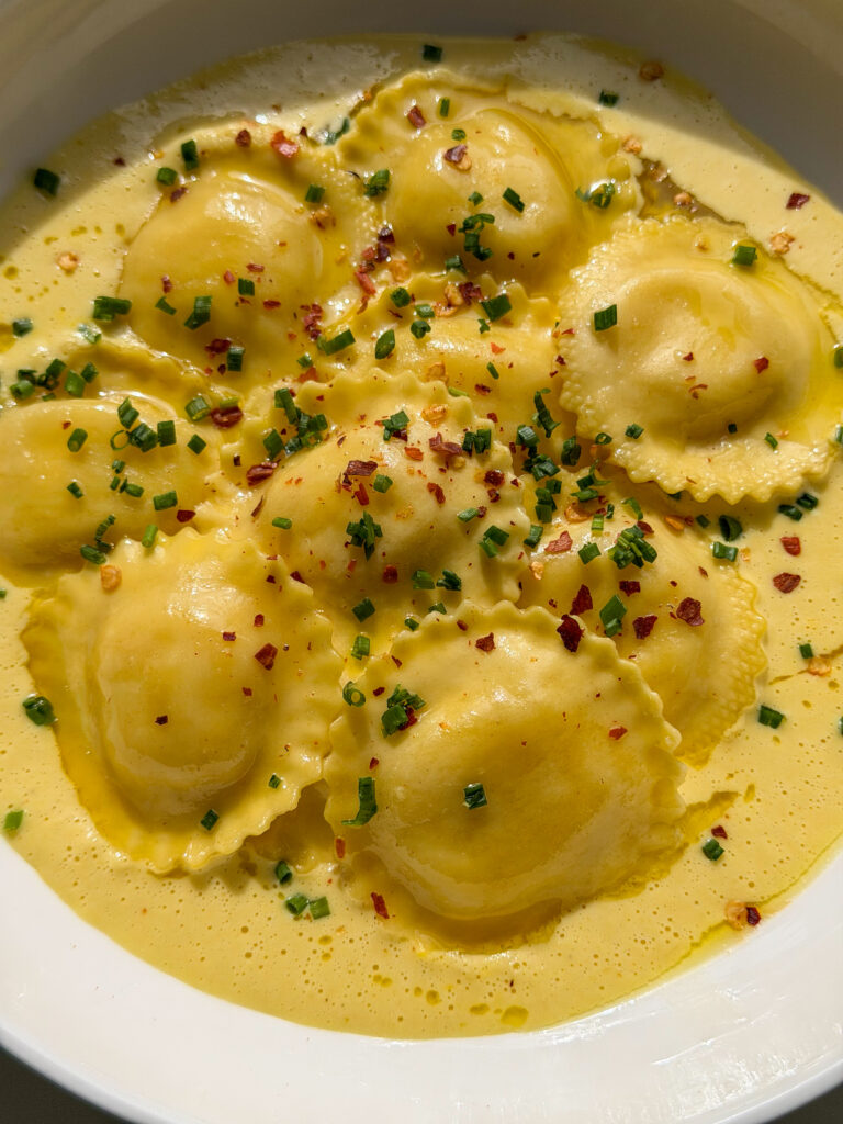 goat cheese ravioli served over silky homemade corn purée with chives