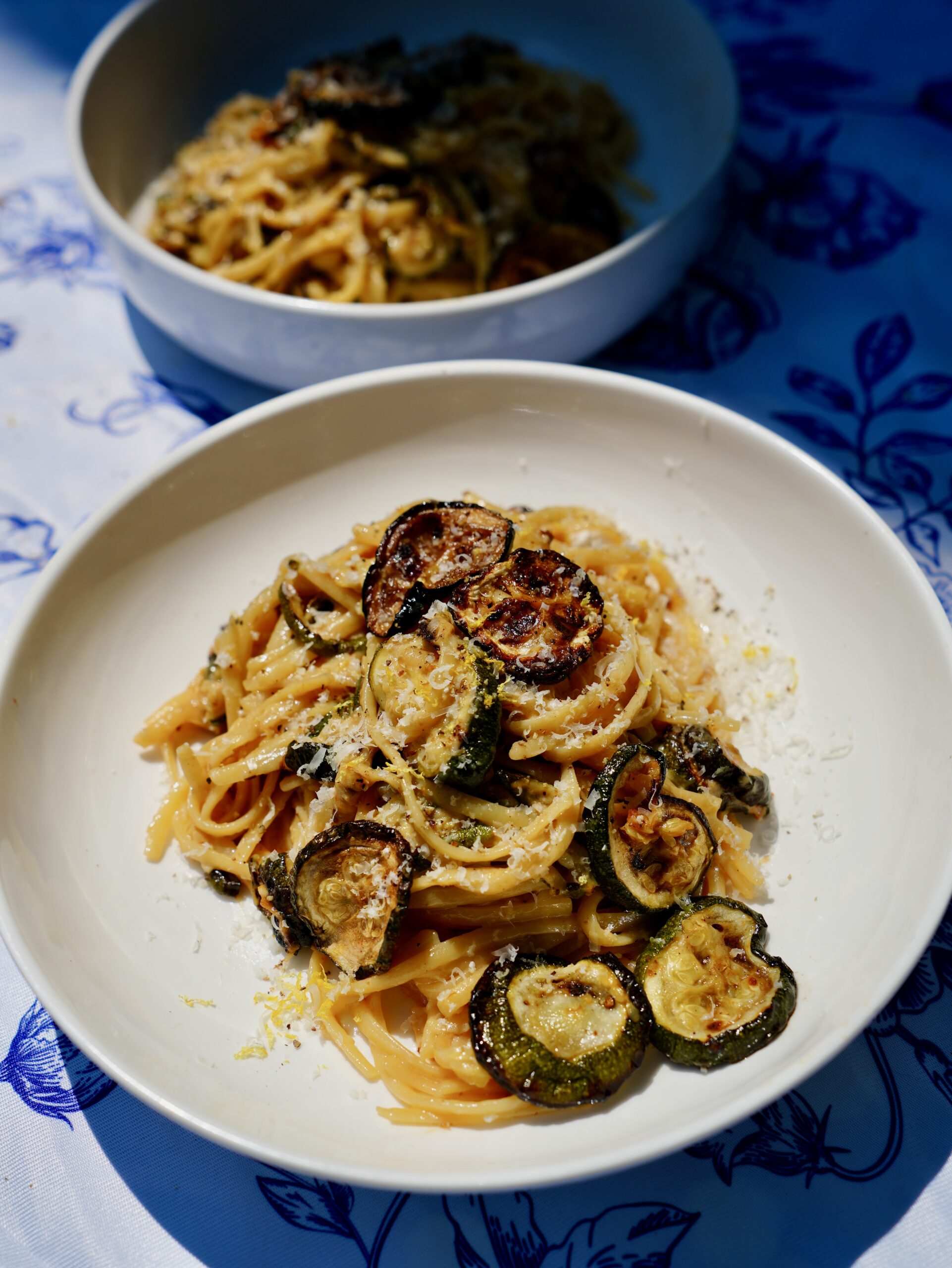 Two bowls of creamy miso Alfredo linguine with caramelized zucchini and Parmesan