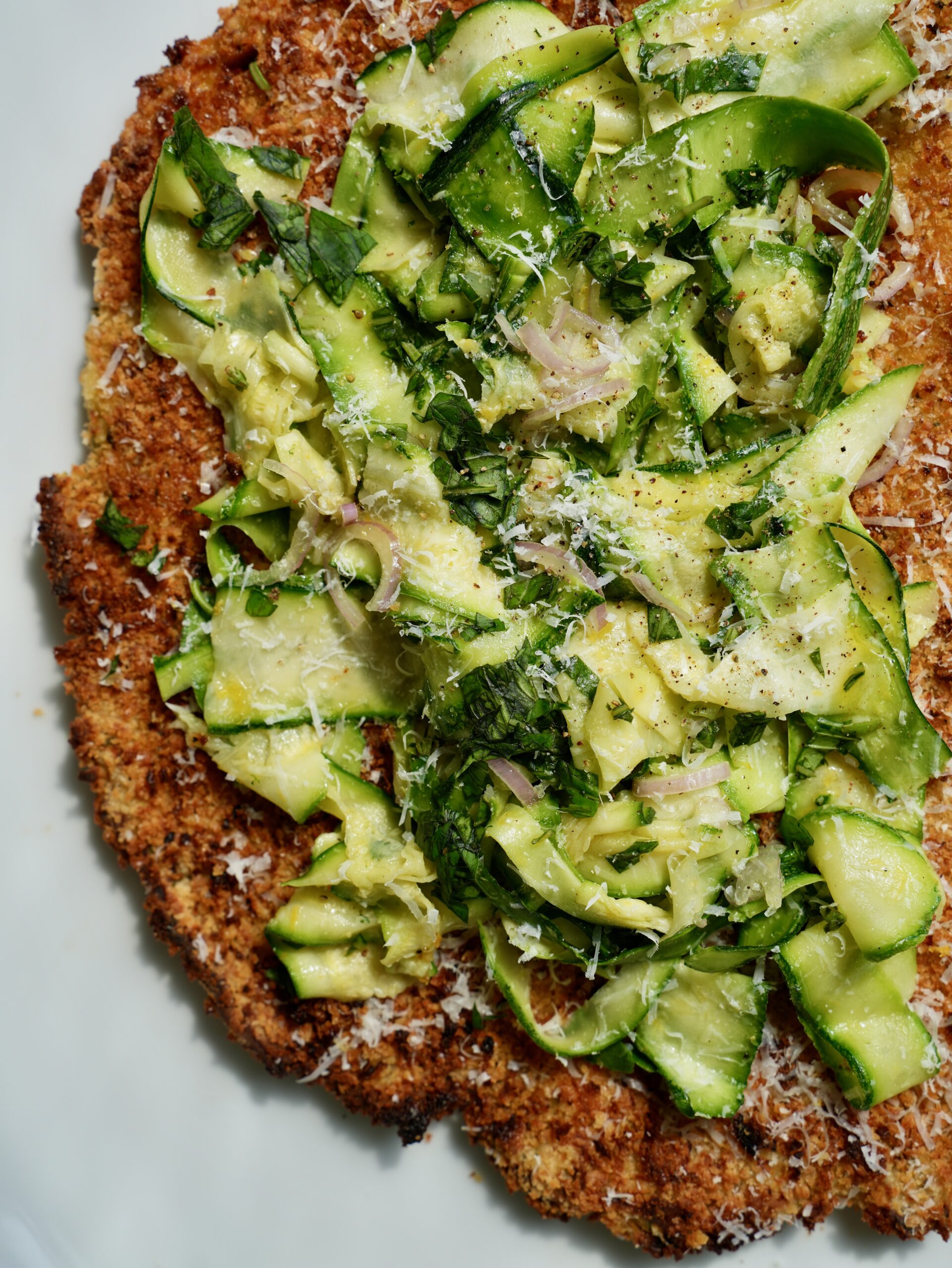 Crispy zucchini chicken cutlet topped with shaved zucchini, shallot, basil and Parmesan