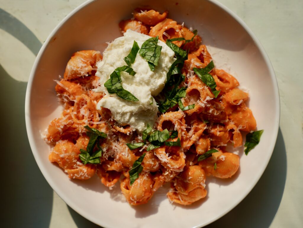 Creamy spicy vodka pasta topped with burrata, Parmesan and fresh basil
