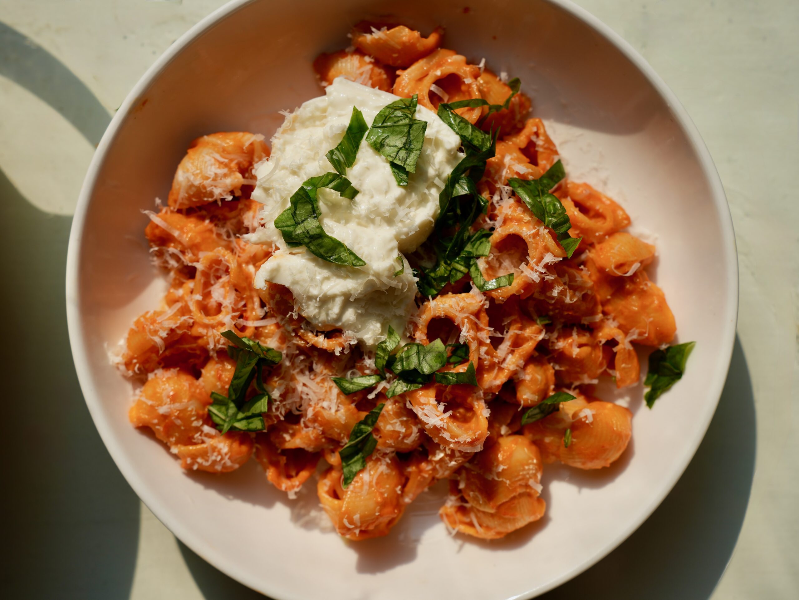 Creamy spicy vodka pasta topped with burrata, Parmesan and fresh basil
