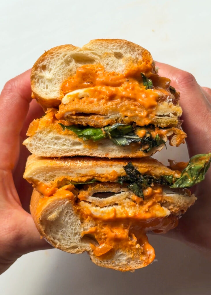 Chicken cutlet sandwich layered with creamy vodka sauce, melted cheese and fresh basil