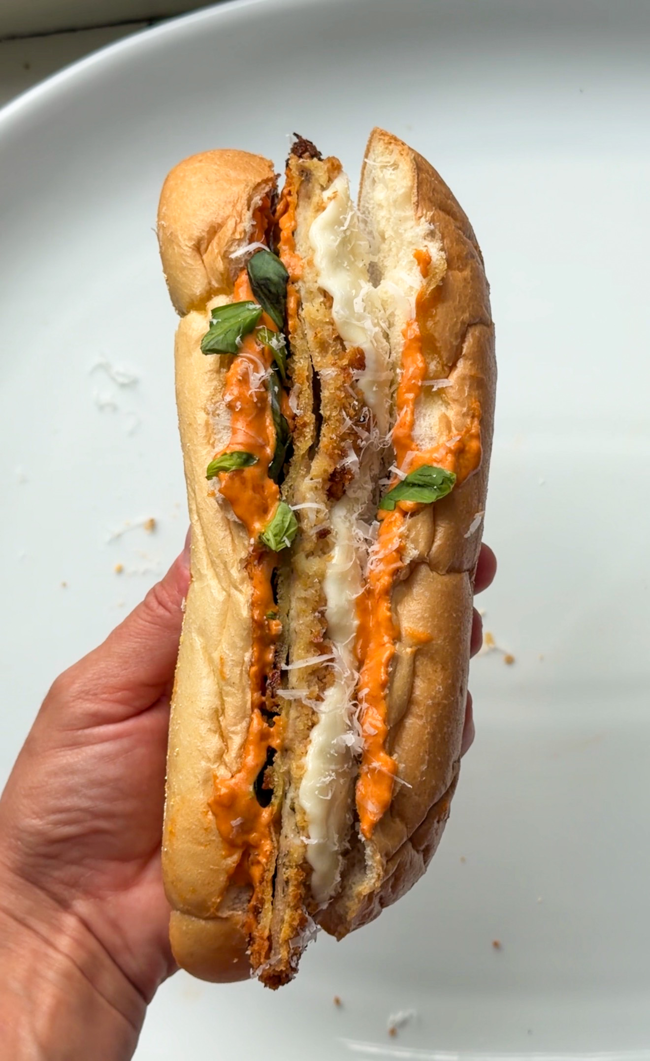 Spicy vodka chicken cutlet sandwich on a hoagie roll with crispy chicken cutlet strips, melted mozzarella, basil, Parmesan, and vodka sauce